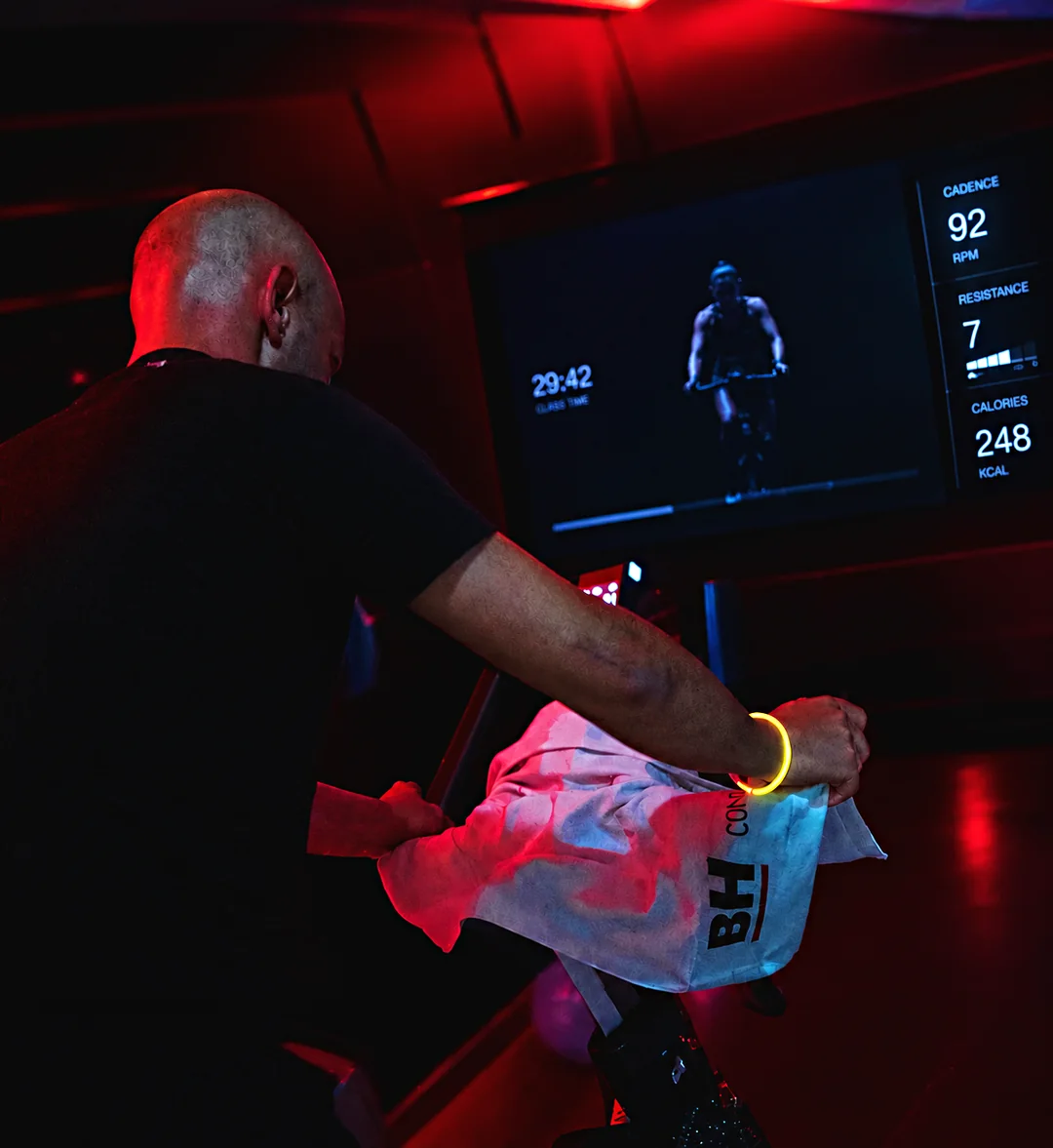 Sócio numa aula virtual de ciclismo com luz vermelha no Arena Fitness